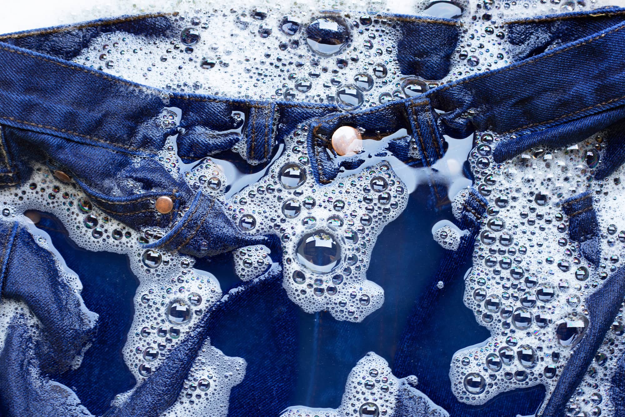 Tessuto in denim immerso nella schiuma del detersivo